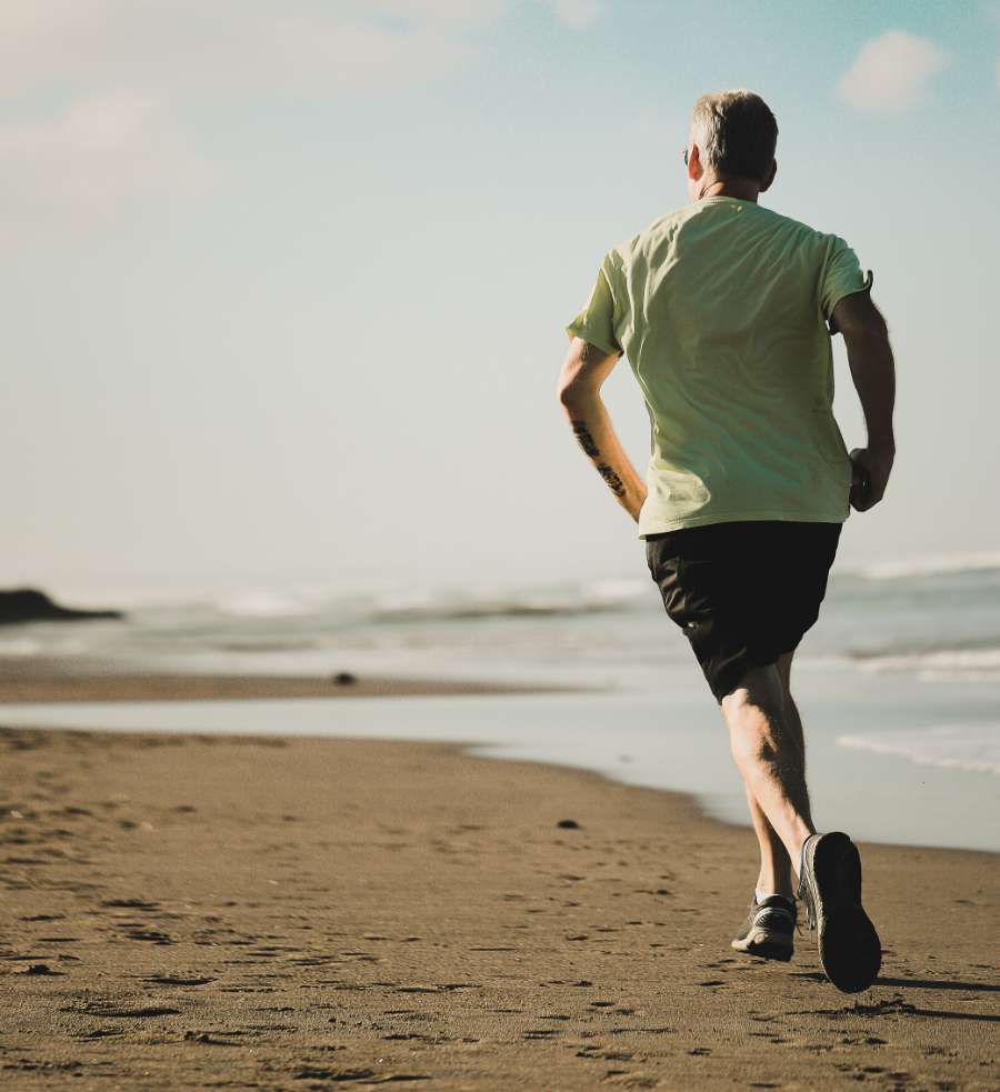 Older Man Running On Beach