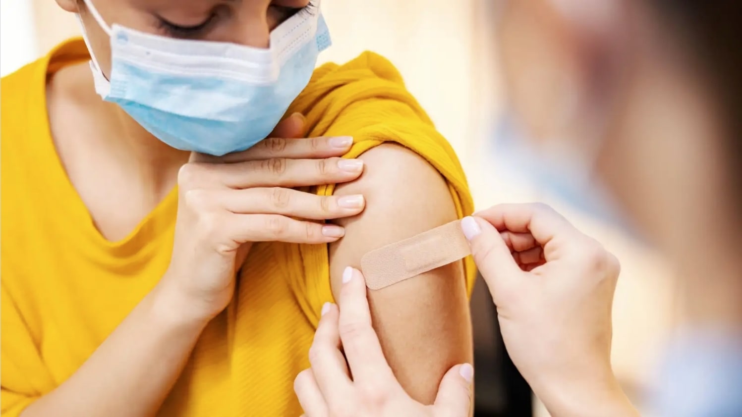 Woman getting a bandaid after receiving a vaccine