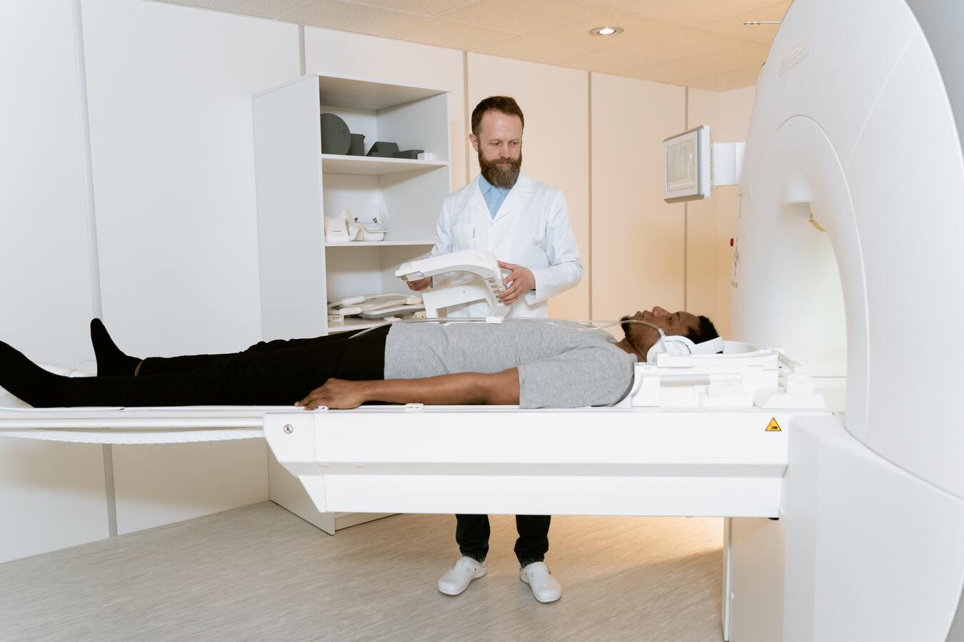 Radiologist technician and their patient going into an MRI machine