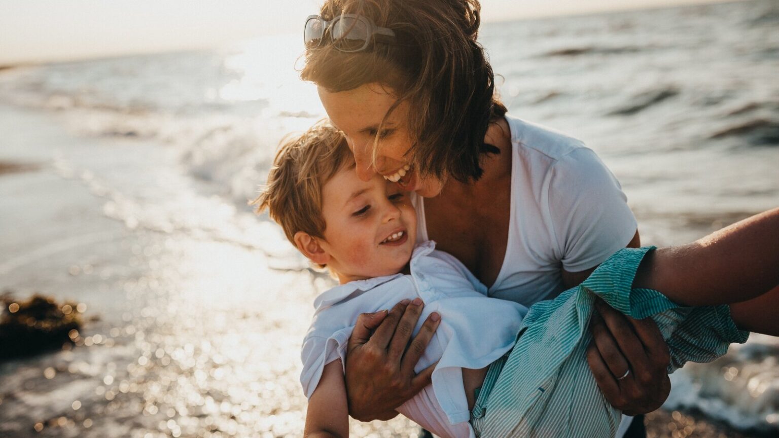 Woman and her son having fun on the beach