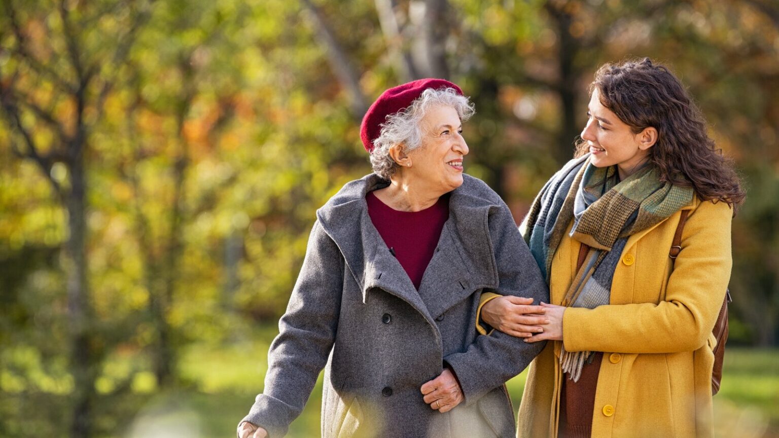 Senior Woman Walking With Granddaughter In Park During the Winter