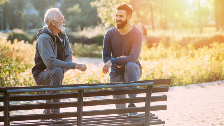 Happy Father And Son Enjoying Outdoors In Park.