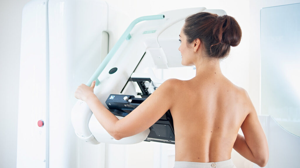 Healthy Young Woman Doing Cancer Prophylactic Mammography Scan At Hospital.