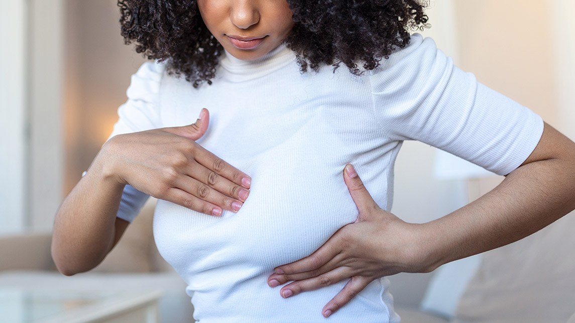 Young African American Woman Palpating Her Breast By Herself That She Concern About Breast Cancer. Healthcare And Breast Cancer Concept